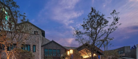 Un edificio moderno con paredes de piedra, ventanas amplias y un área de entrada bien iluminada.