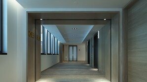 A long, narrow hallway with a patterned carpet, wooden paneling on the walls, and a ceiling with recessed lighting. - Holiday Inn Express - Zhejiang Qianxia Lake by IHG (Lishui)
