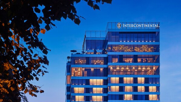 Un hôtel InterContinental moderne, avec une façade en verre et des fenêtres illuminées.