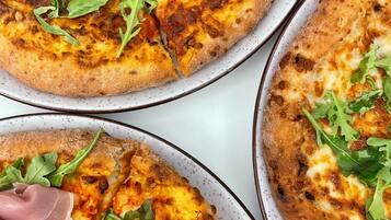 Tres pizzas con distintos ingredientes, sobre platos.