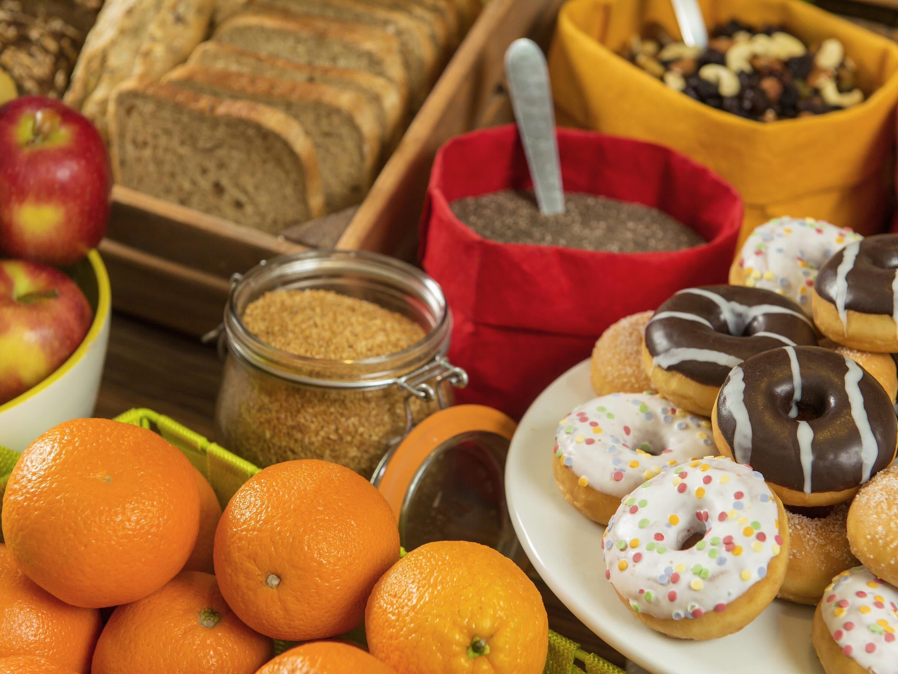 A variety of food items including oranges, donuts, and bread.