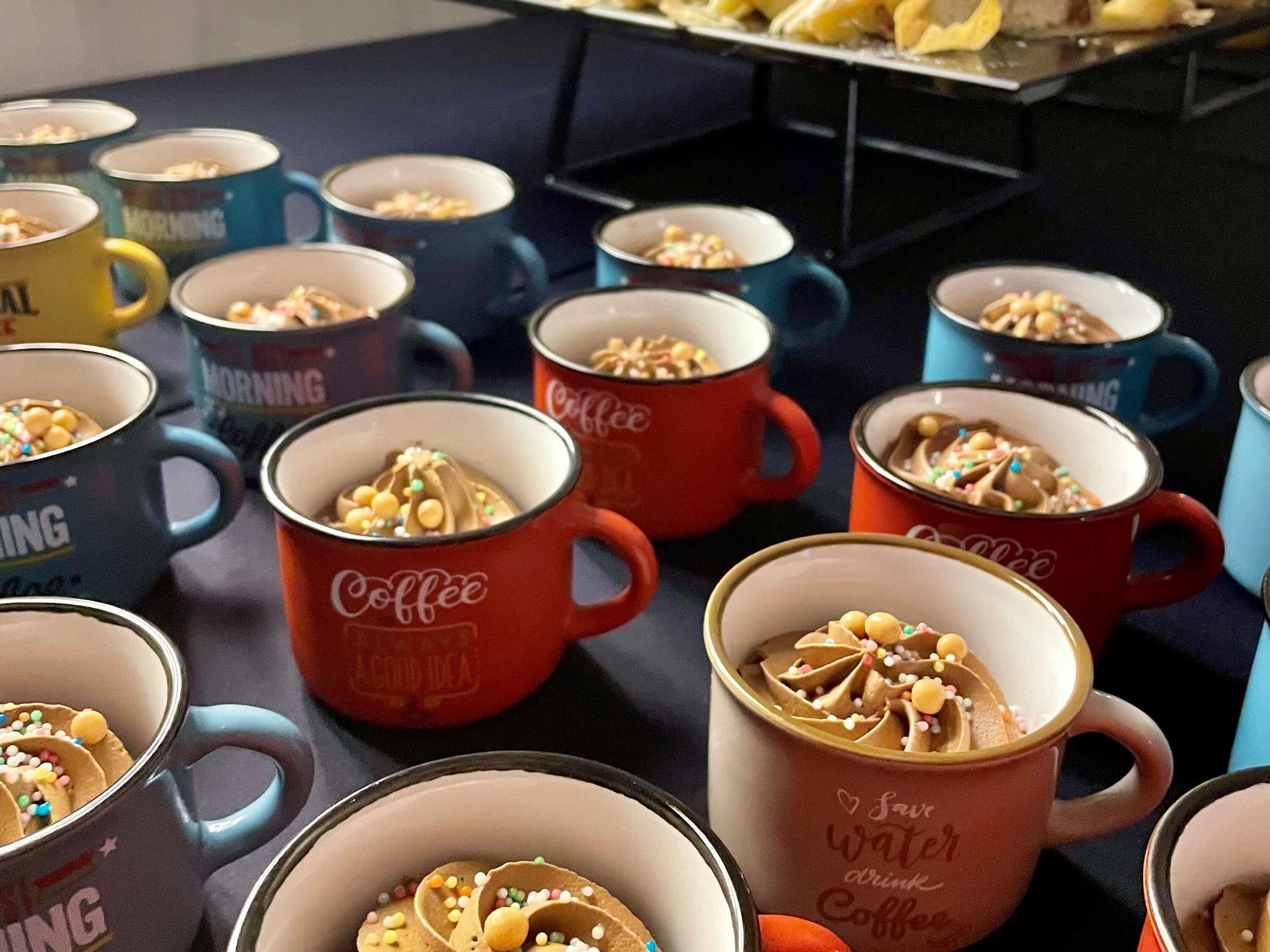 Una mesa con varias tazas de café, algunas etiquetadas con 'Coffee' y otras con 'Morning'.