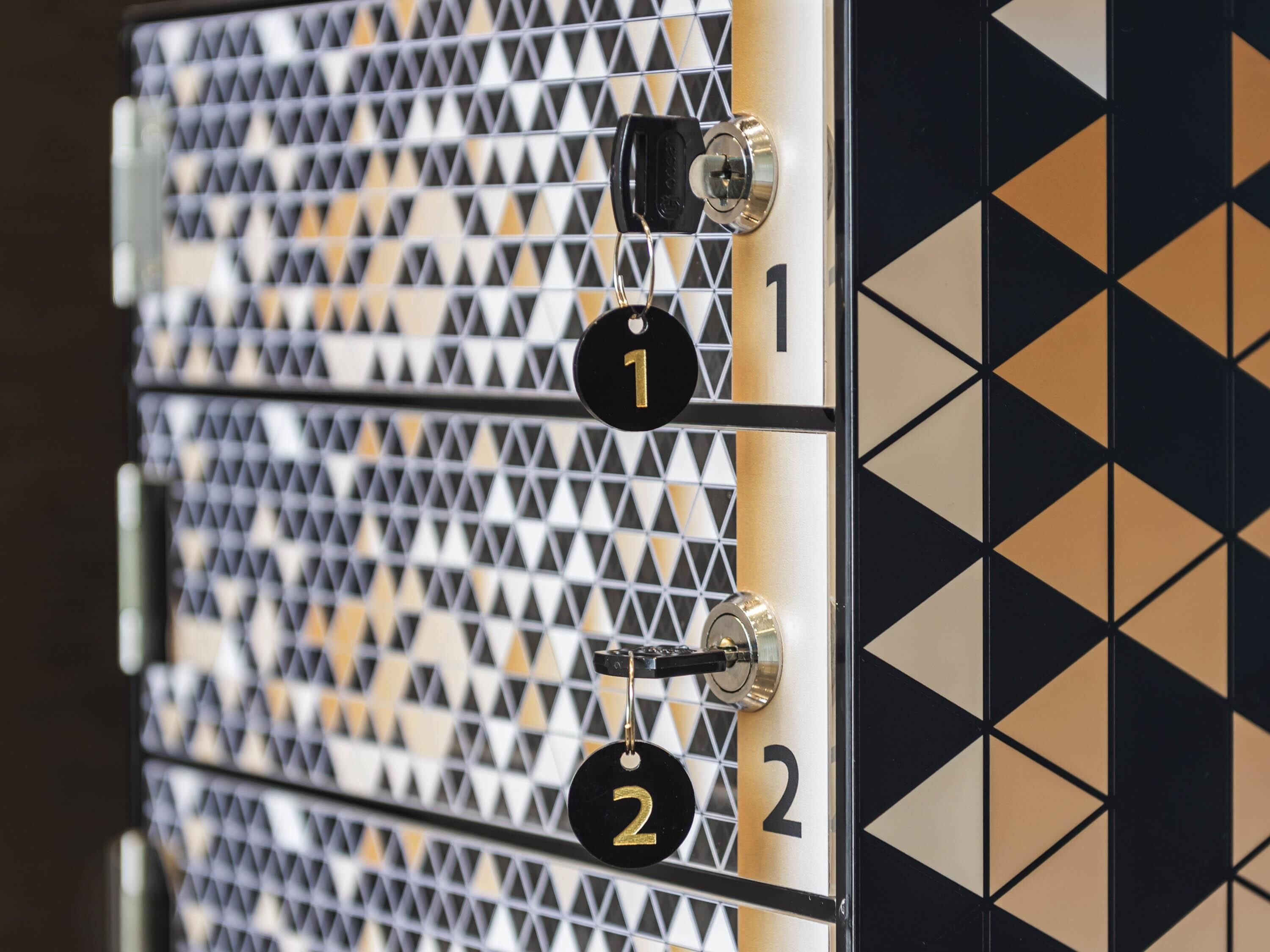A wall with a geometric pattern and numbered locks, suggesting a secure storage or access system.