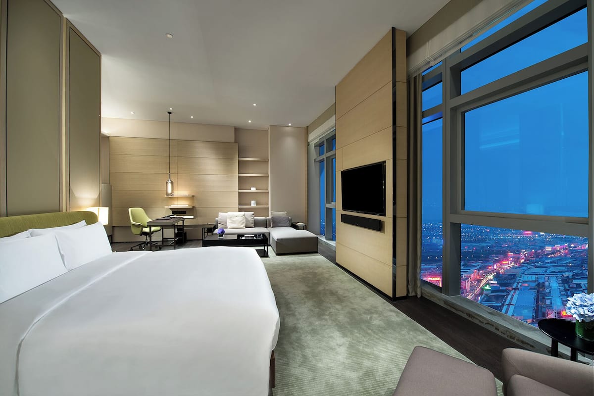 Relax in a spacious room with a large bed, flat-screen TV, and city views.