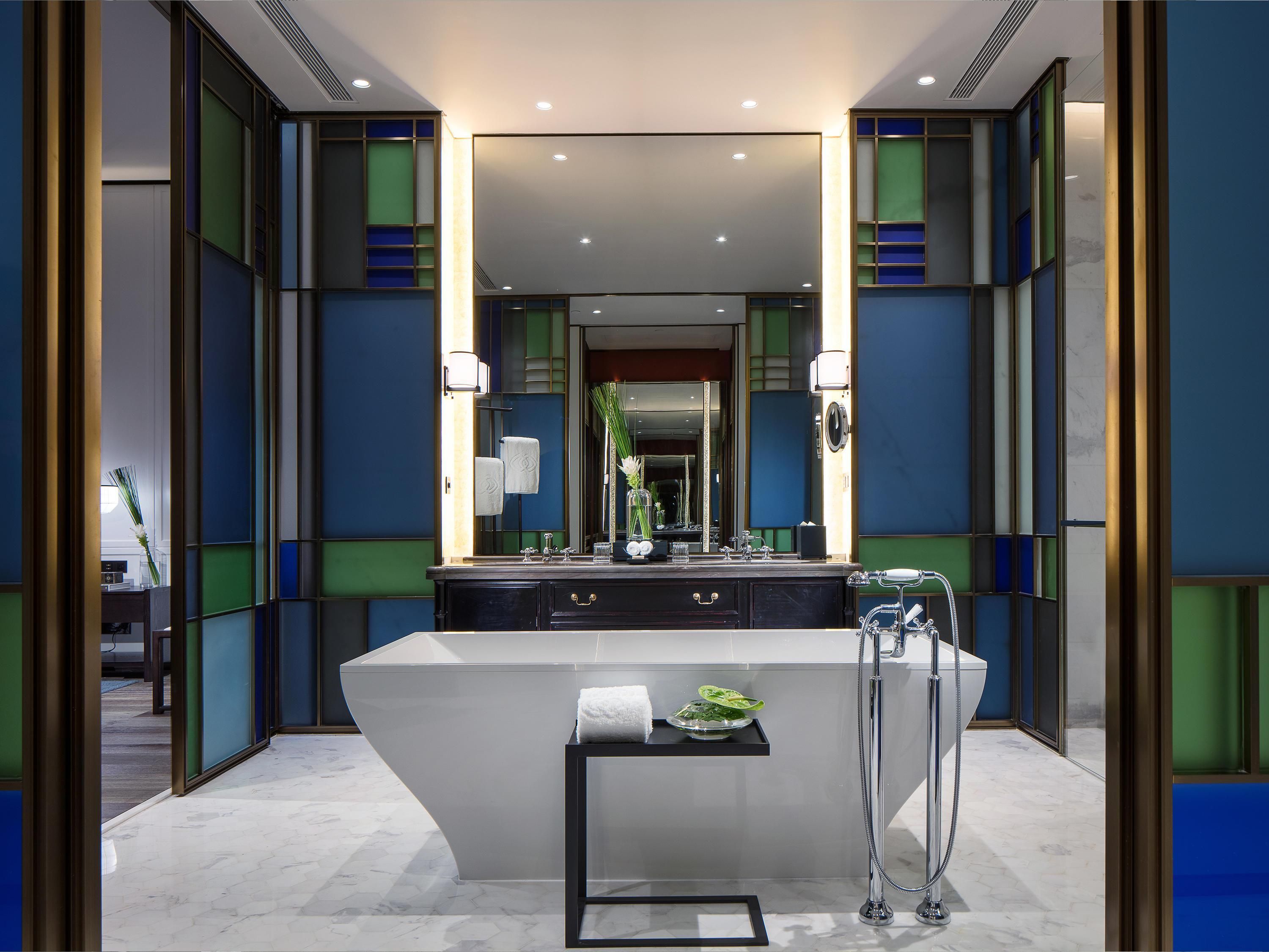 A modern bathroom with a large mirror, a white vanity, and a shower area.