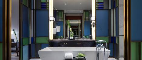 A modern bathroom with a large mirror, a white vanity, and a shower area.