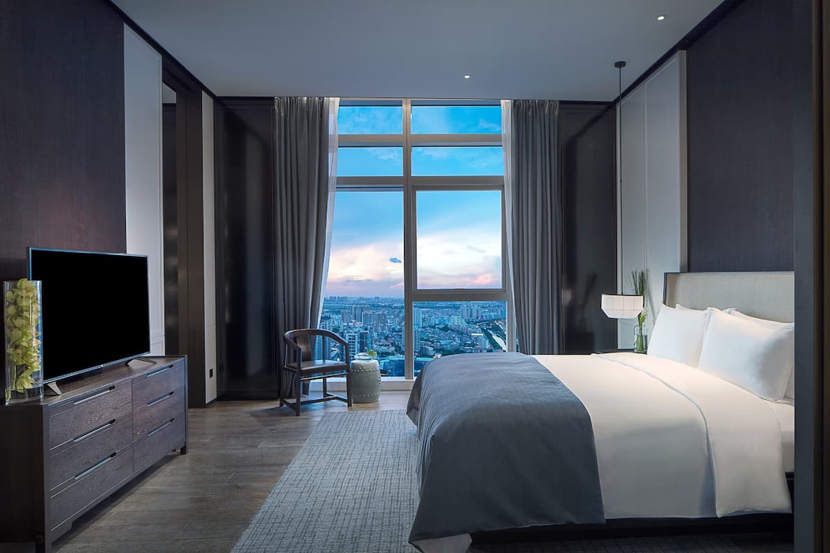 Enjoy a panoramic city view from the large window, with a comfortable seating area and a flat-screen TV.