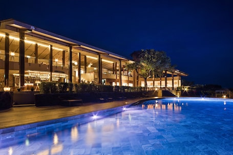 Una piscina al aire libre, sillones reclinables de piscina