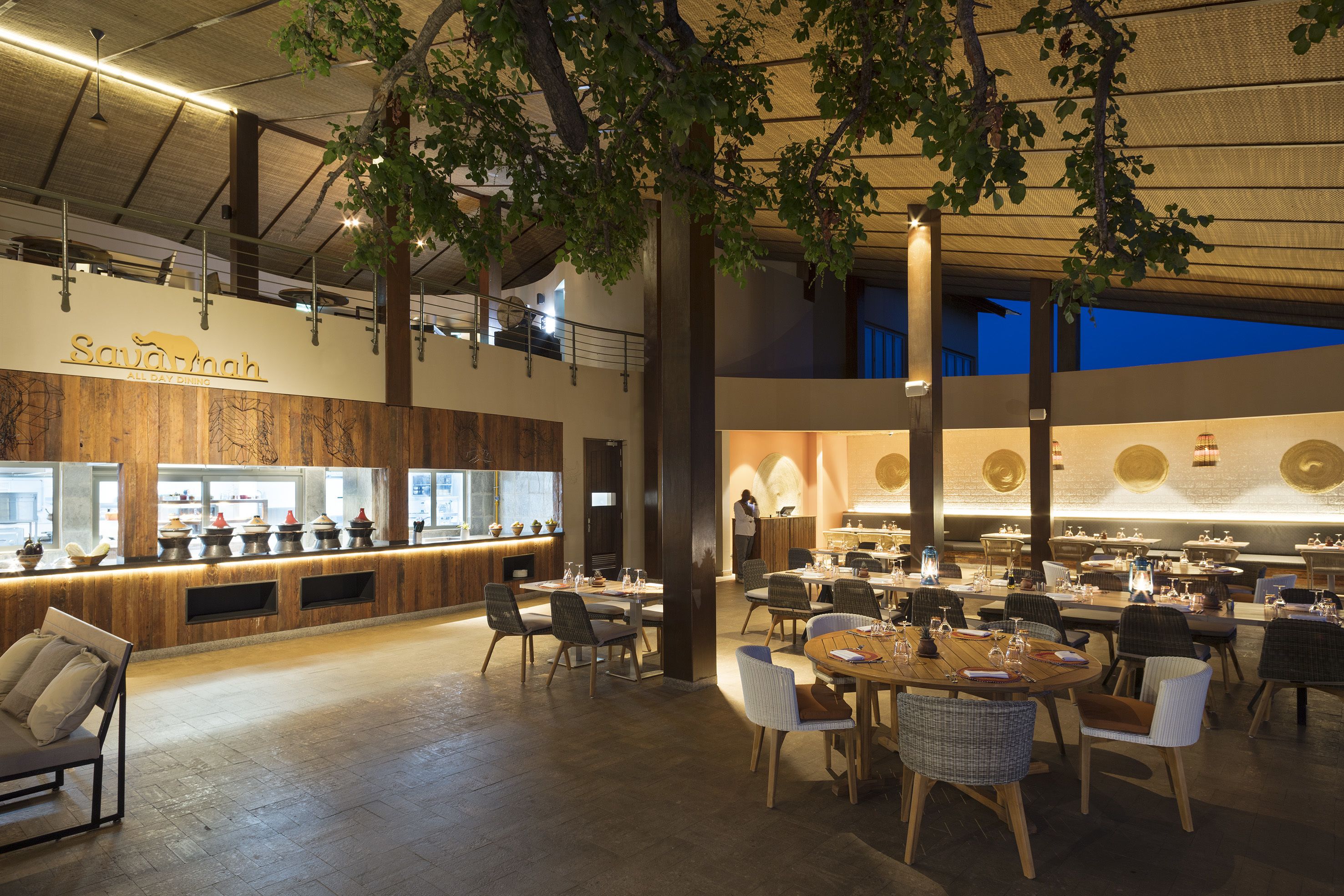 A spacious restaurant with high ceilings, exposed beams, and a variety of seating arrangements.