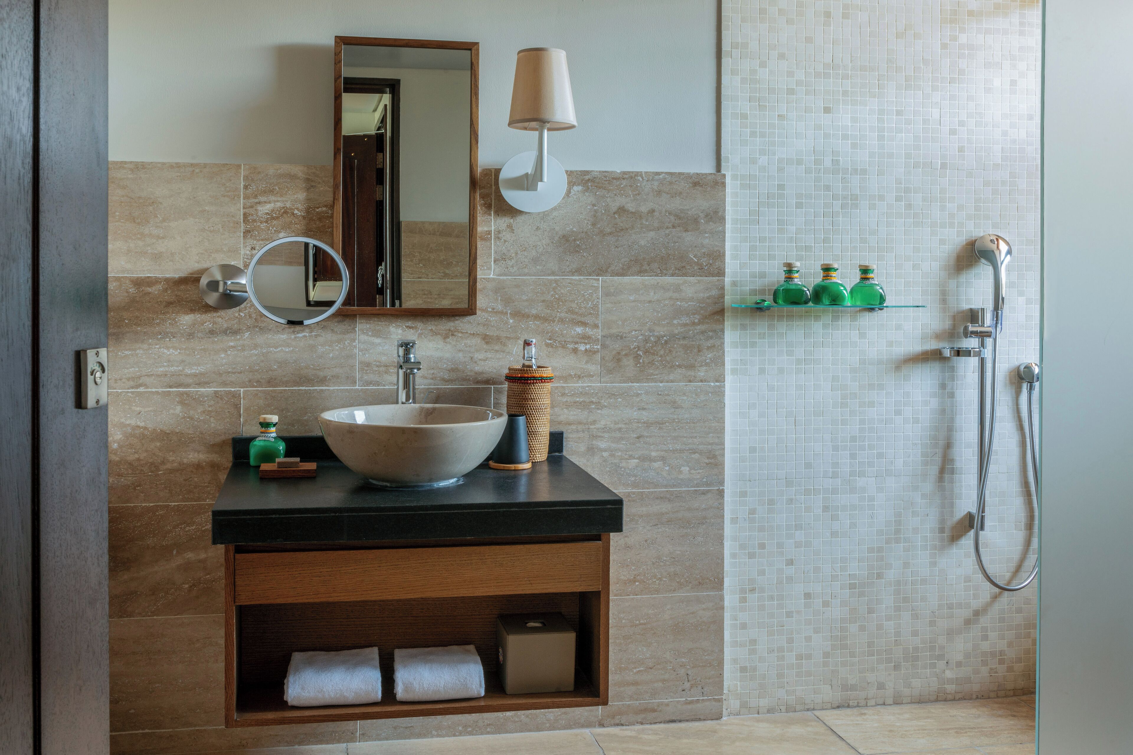 Ein Badezimmer mit einem großen Waschbecken, einem Spiegel und einer Duschkabine.