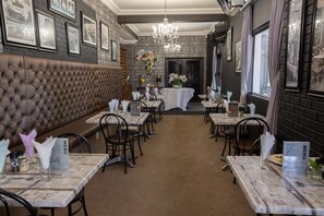 Ein Restaurantinneres mit einer zentralen Sitzgruppe, die eine gepolsterte Lederecke und Tische mit Speisekarten sowie Stühle umfasst.