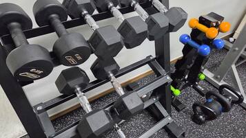 A home gym with a variety of dumbbells and weight equipment.