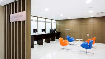 Ein Businesscenter mit Empfangstresen, Computern und moderner Sitzgelegenheiten.