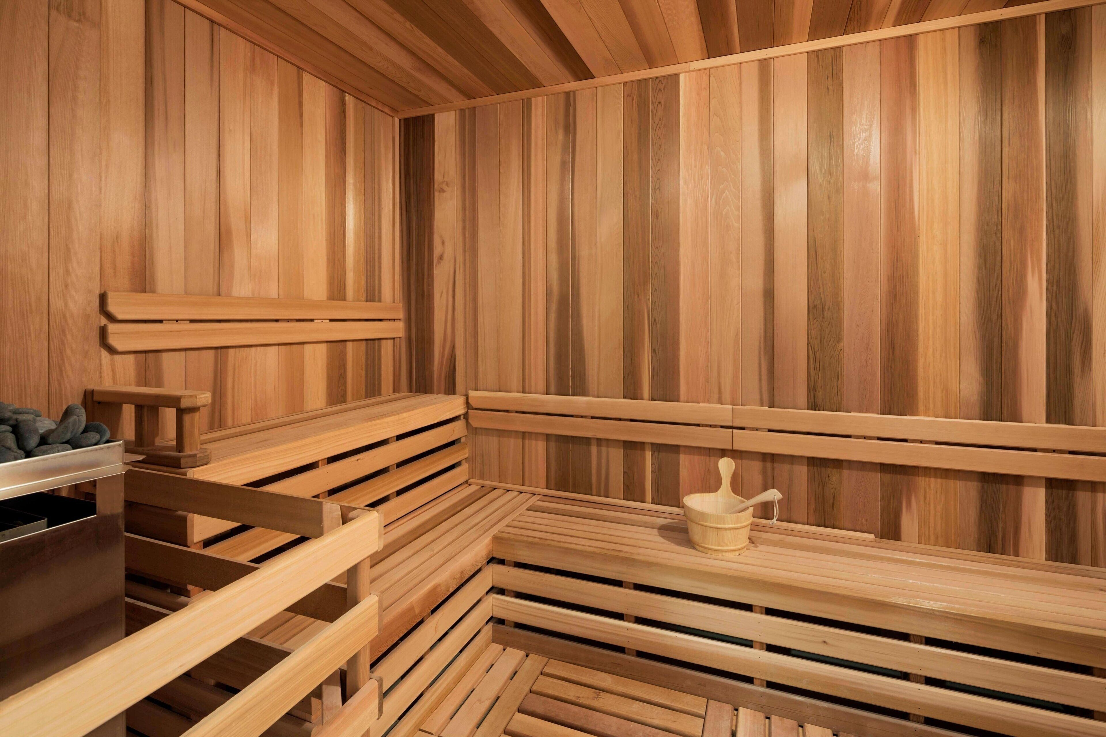 A sauna with wooden benches and a small table with a container.