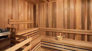 A sauna with wooden benches and a small table with a container.