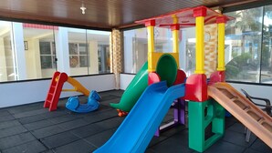Ein Kinderspielbereich mit mehreren Rutschen und Klettergerüsten.