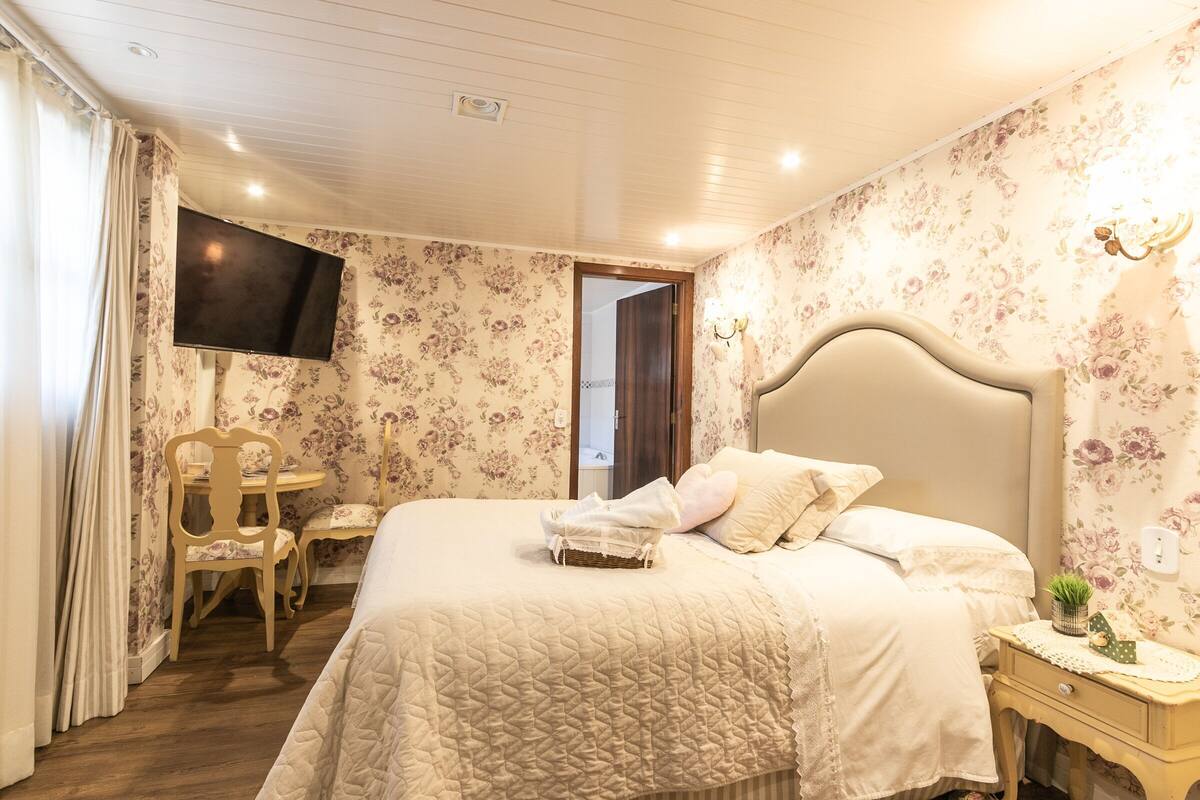 Une chambre à coucher avec un lit, une télévision, un bureau et une chaise.