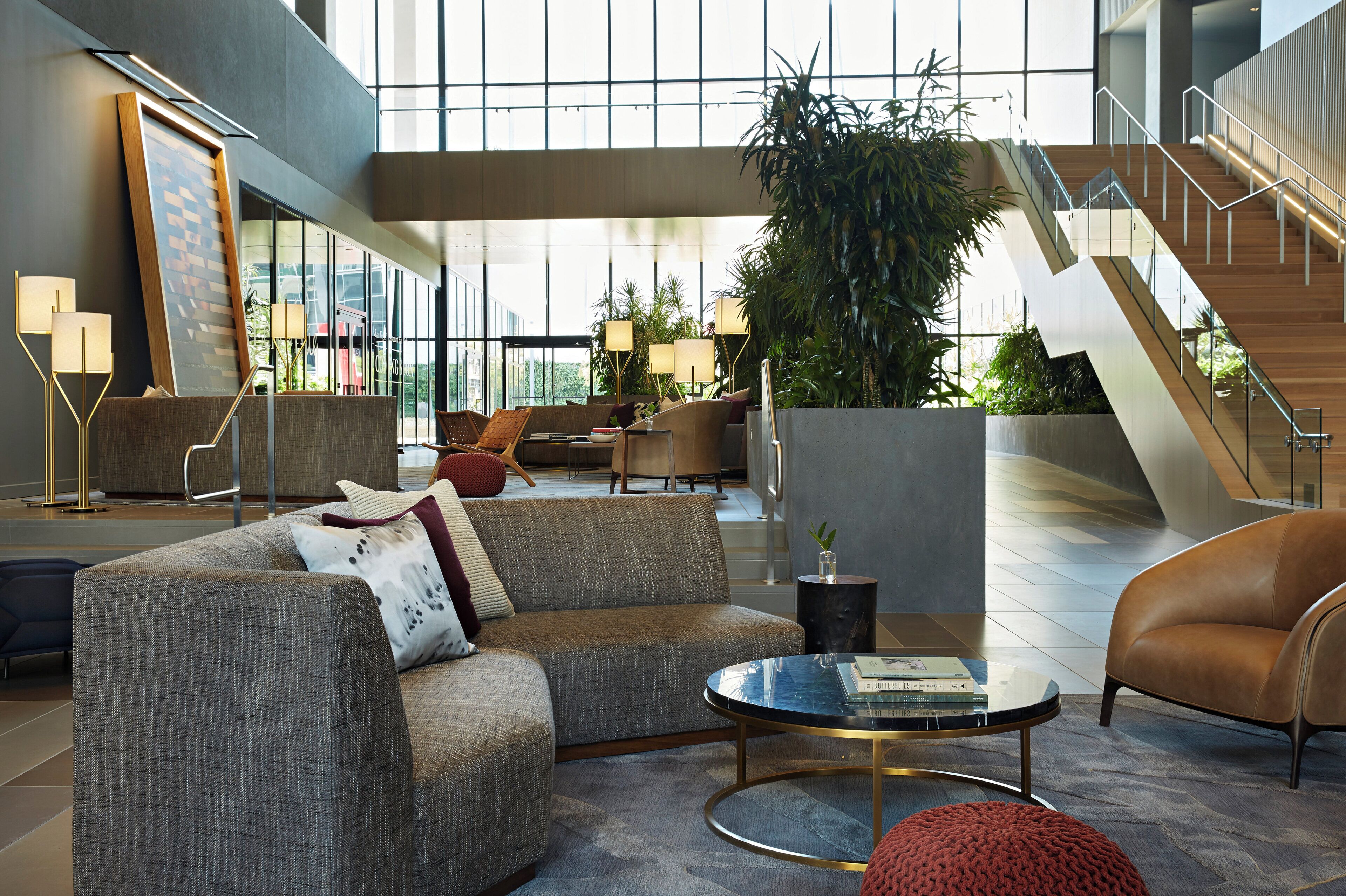 Un lobby moderno con un sofá, una mesa de centro y una escalera.