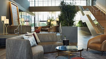 Un lobby moderno con un sofá, una mesa de centro y una escalera.