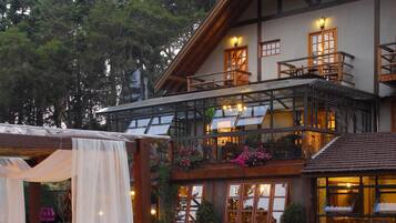 A two-story lodge with a balcony, outdoor seating area, and a fire pit.