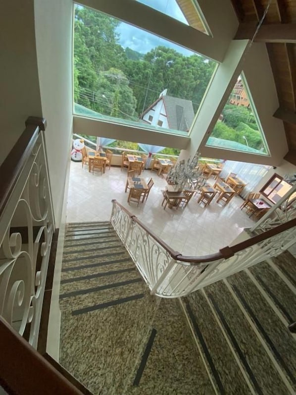 Habitación con techos altos y una escalera que lleva a un balcón.
