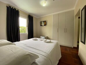 Une chambre d’hôtel équipée d’un lit, d’un bureau, d’une télévision et d’une armoire.