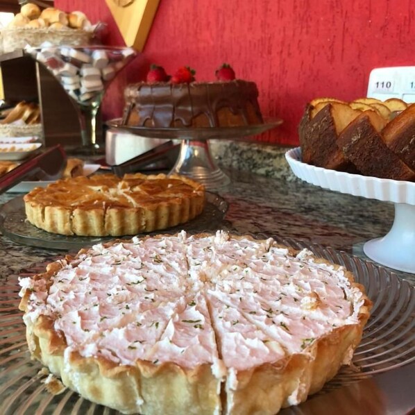 Un présentoir de desserts avec divers gâteaux et pâtisseries disposés sur des plateaux.