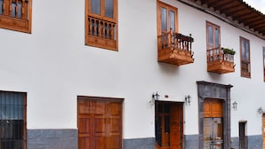 Un bâtiment doté de nombreuses portes et fenêtres en bois, dont certaines sont surmontées de balcons.