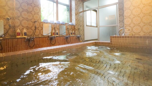 Un cuarto de spa con un amplio jacuzzi, múltiples cabezales de ducha y un ventanal que proporciona luz natural.