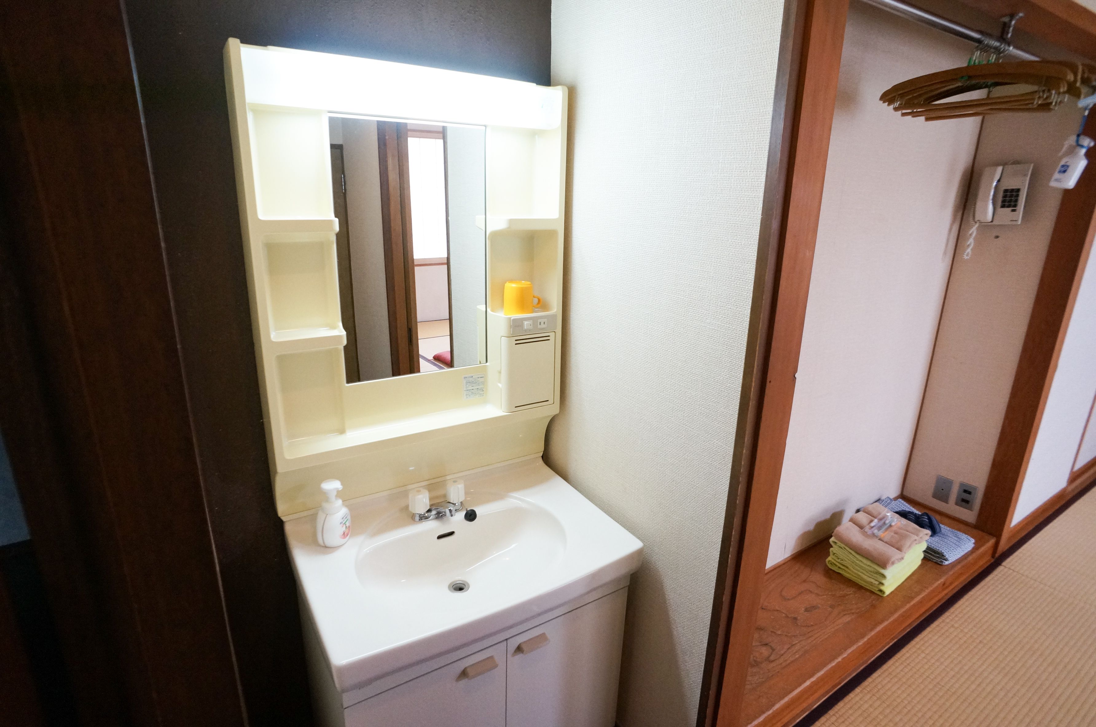 A bathroom with a white sink, a mirror, and a towel rack.