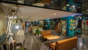 A modern interior with seating areas, plants, and a staircase leading to an upper level. - Finders Hotel-Fu Qian (Taipei)