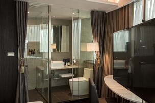 Een moderne badkamer met een douchecabine van glas, een toilet, een wastafel en een badkamermeubel met een spiegel.