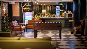A lobby with a foosball table, seating area, and a bar. - Finders Hotel-Fu Qian (Taipei)