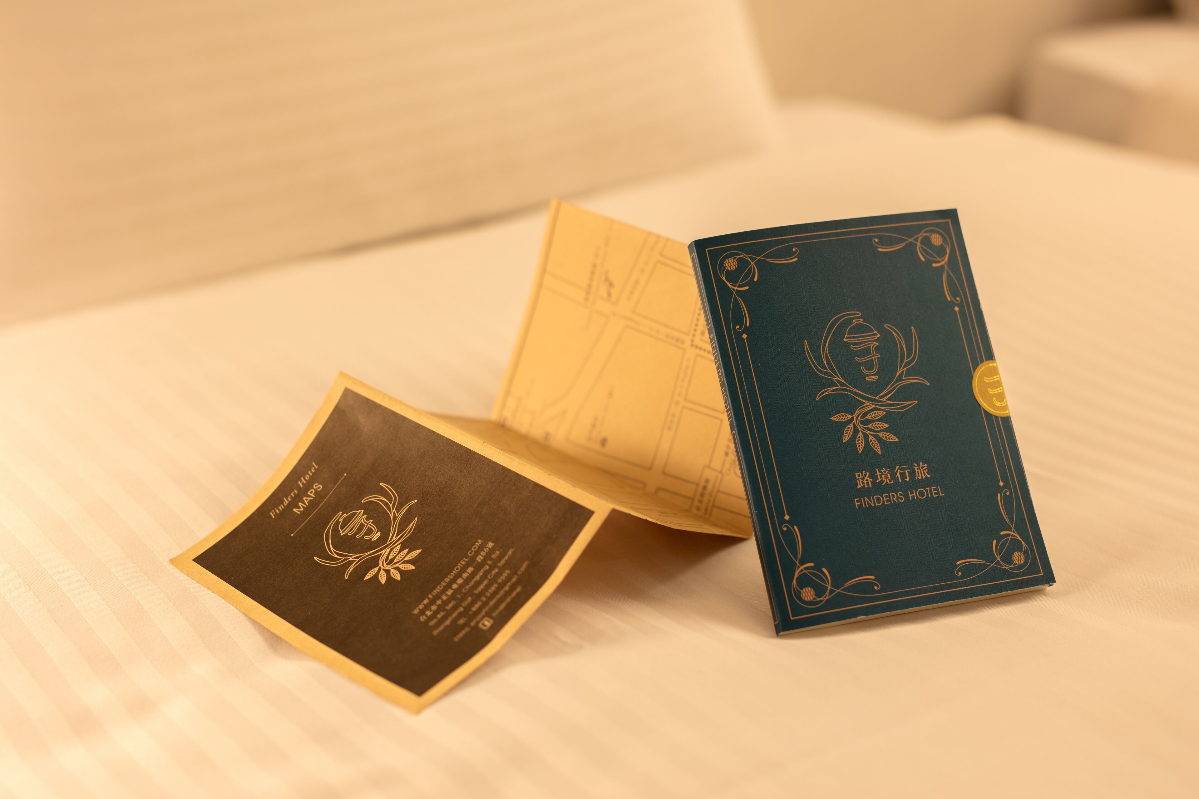 A hotel brochure and a map on a bed.
