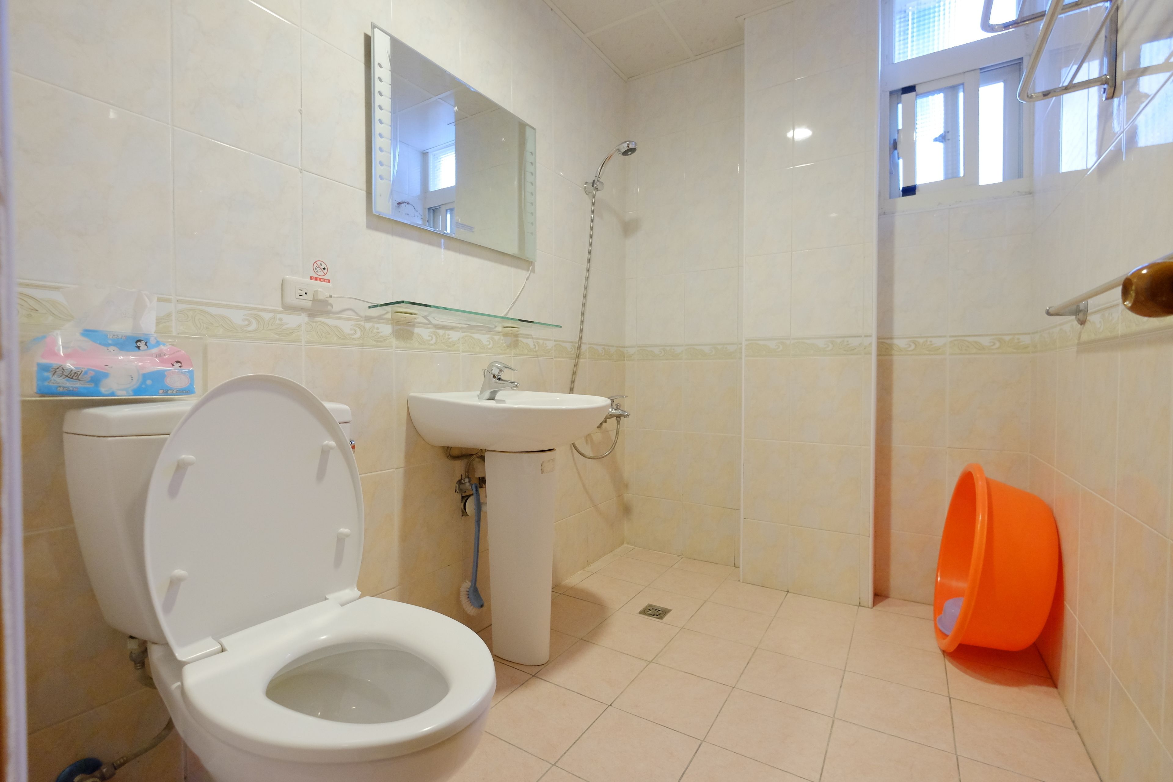 A bathroom with a toilet, sink, and shower.