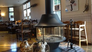 Una habitación acogedora con una chimenea grande, muebles de madera y suelo de ladrillo.