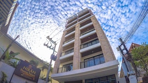 A multi-story building with a sign reading "HIRAN Patong Palace". - Hiran Residence (Patong)