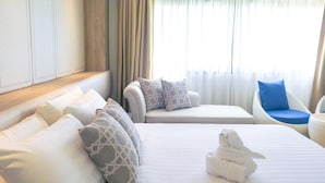 A hotel room with a large bed, a sofa, and a chair. - Hiran Residence (Patong)