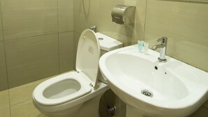 Ein Badezimmer mit Toilette, Waschbecken und Dusche.