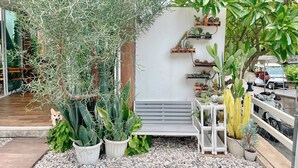 A garden area with various potted plants, a bench, and a small table. - Check-in Resort Koh Larn (Koh Lan)