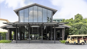A modern building with a glass facade and a covered entrance area. - Theatre Residence (Bangkok)