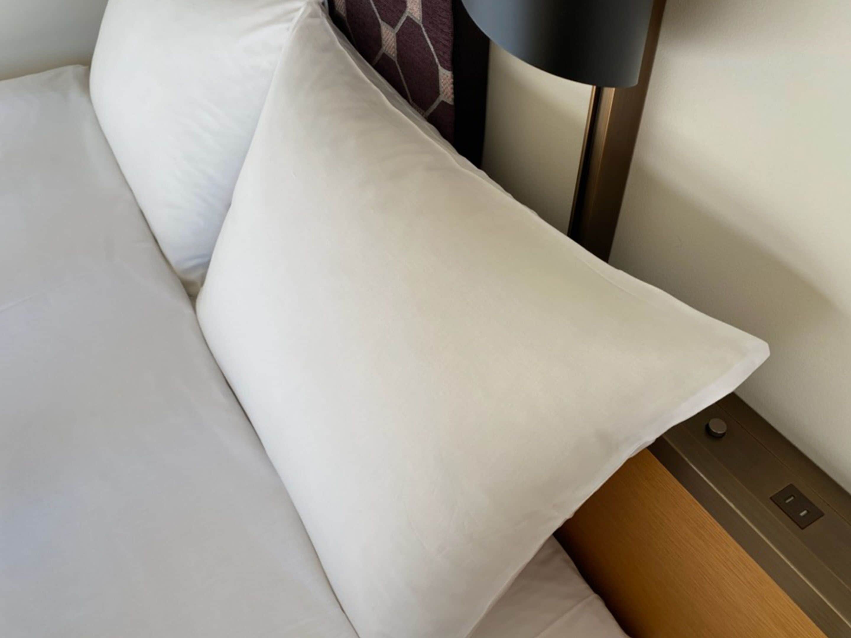 A bed with white bedding and a wooden headboard.