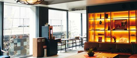 A modern interior with a seating area, a coffee machine, and a bookshelf.