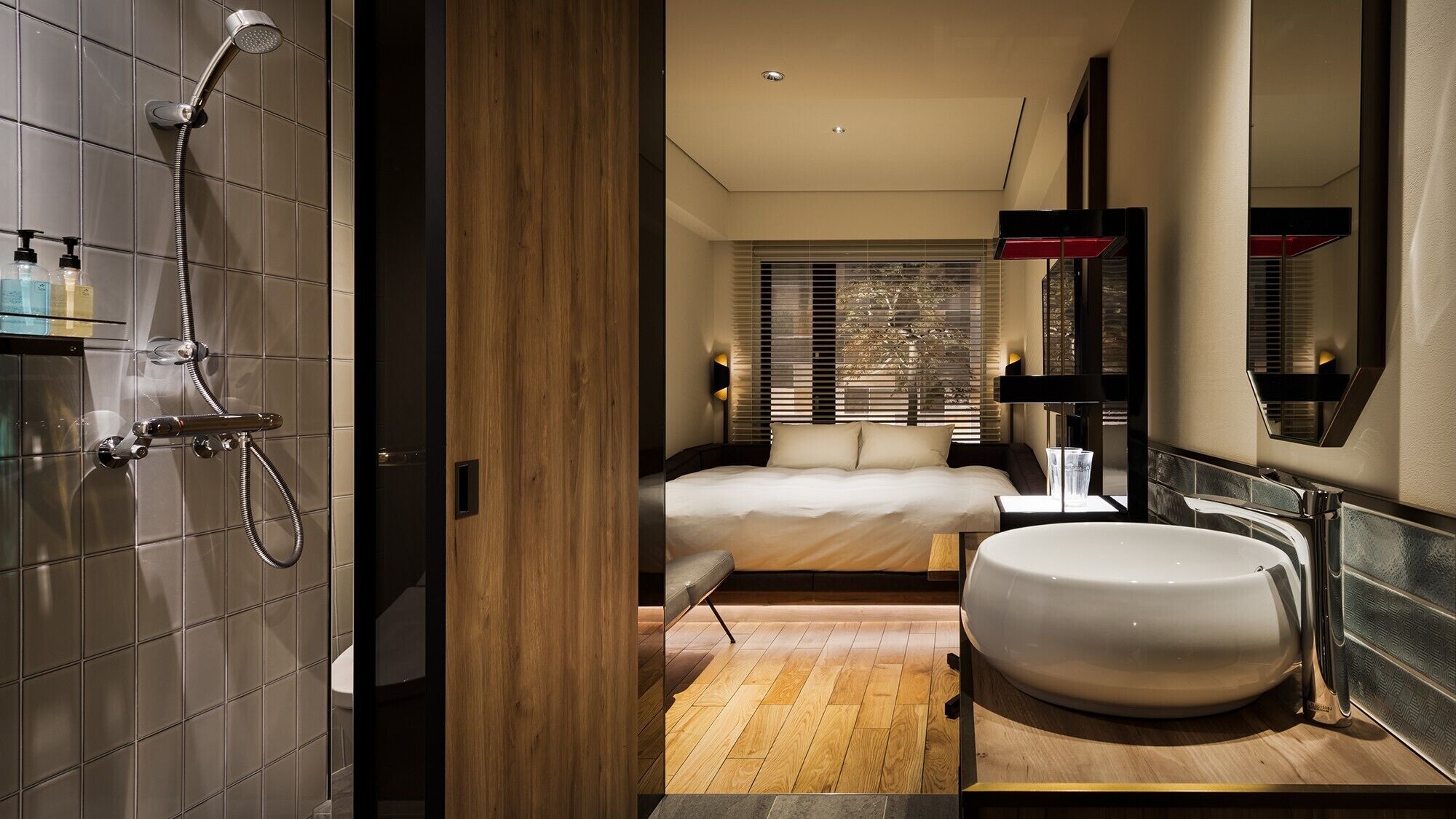 Un baño moderno con ducha, un lavamanos grande y una cama con vistas al exterior.