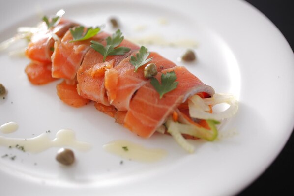A dish of rolled salmon with vegetables and capers on a white plate. - Pension Arumu (Hakuba)