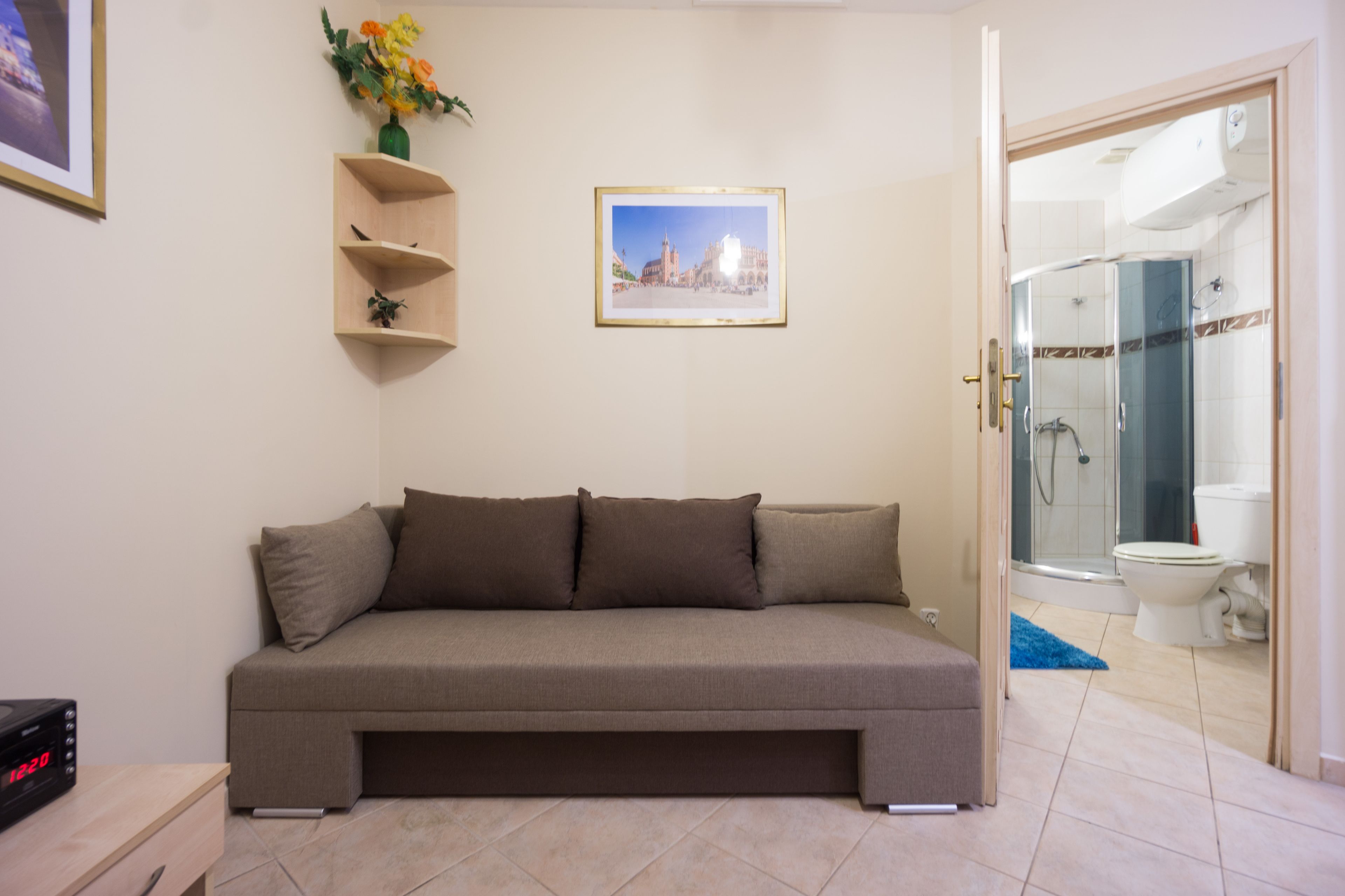 Een moderne woonkamer met een bank, een ingelijst schilderij aan de muur en een tafeltje met een klok.