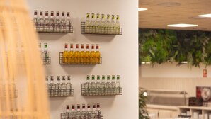 A wall with multiple shelves displaying bottles of beverages. - Ona Palamós (Palamós)