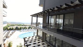 Un área de piscina en la azotea con sillones de descanso y vistas al paisaje.