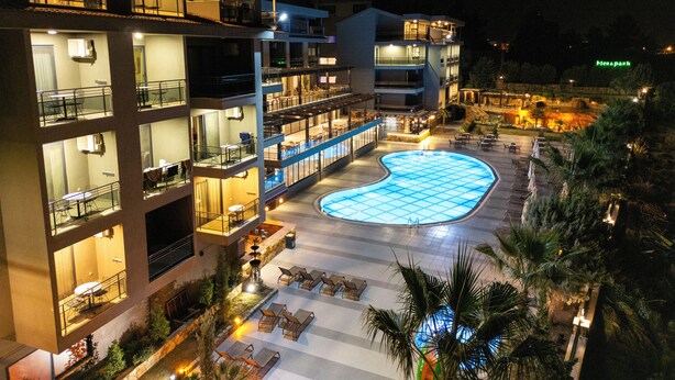 A multi-story hotel with a swimming pool, outdoor seating, and a view of a park. - Hierapark Thermal & Spa Hotel (Denizli)