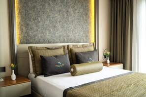 A hotel room with a large bed, two nightstands, a vase with flowers, and a wall-mounted light fixture. - Hierapark Thermal & Spa Hotel (Denizli)